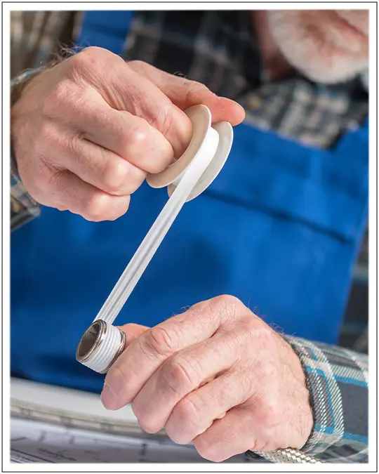 Plumber Demonstrating wrapping Pipe Threads with Thread Seal Tape or Teflon Tape
